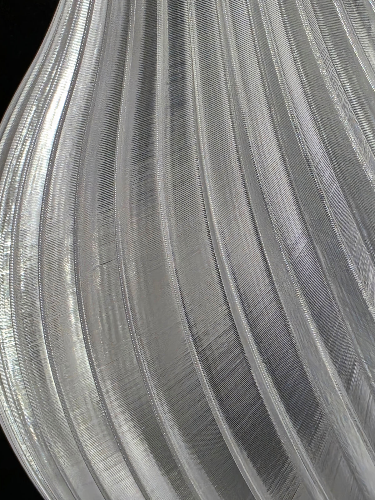 Close-up of a textured clear vase with concentric circular patterns