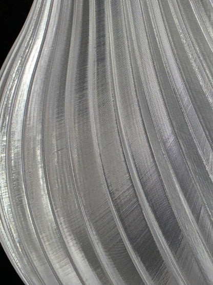 Close-up of a textured clear vase with concentric circular patterns