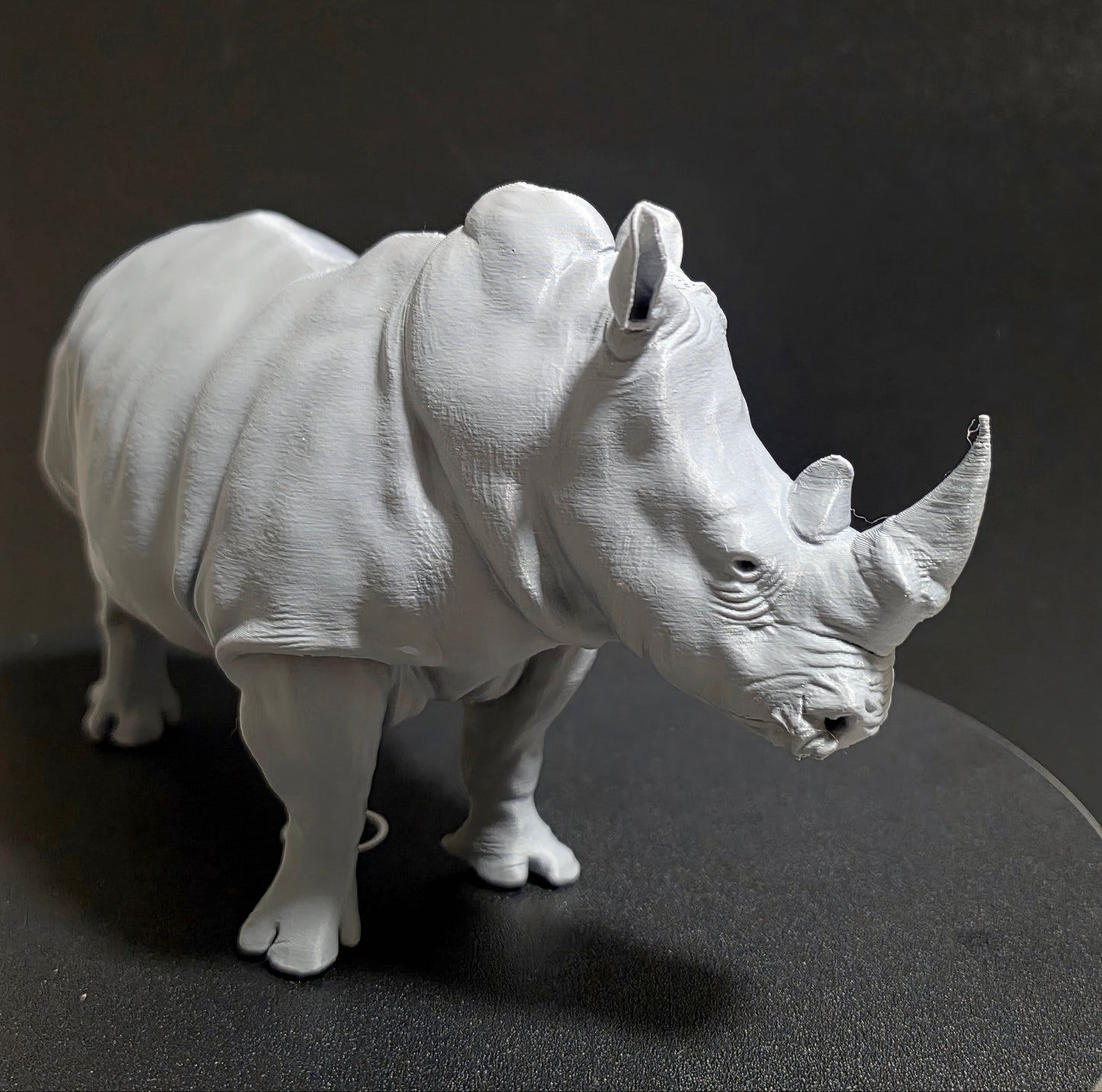 White ceramic sculpture of a dog on a dark background