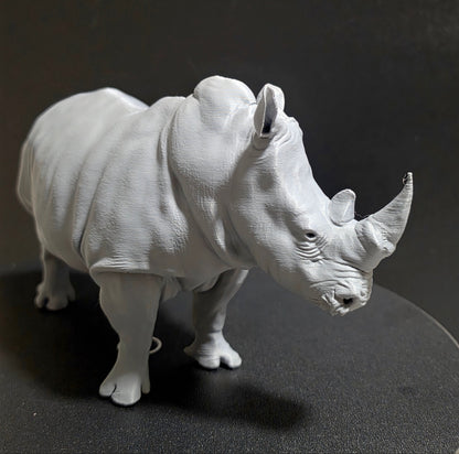 White ceramic sculpture of a dog on a dark background