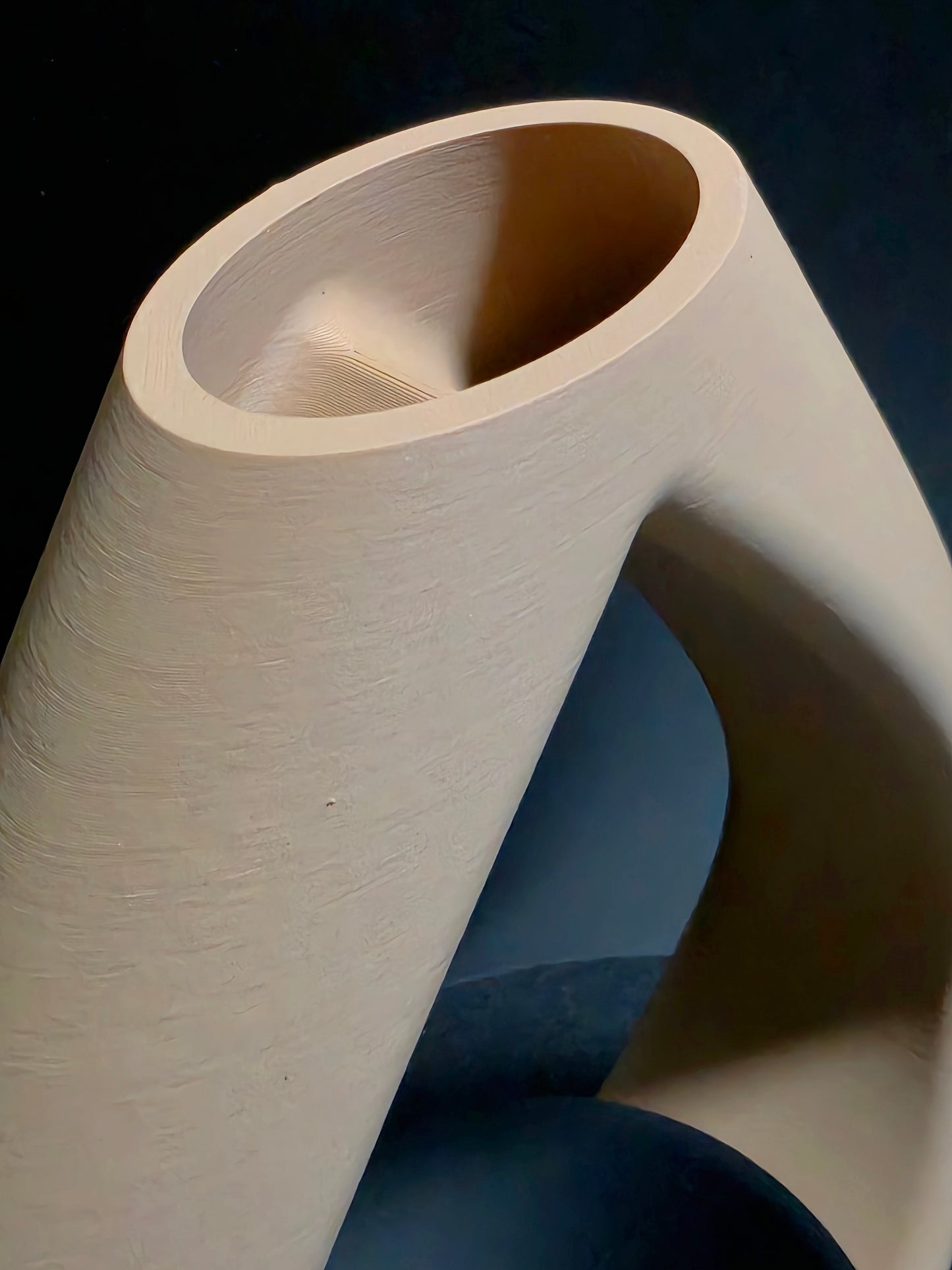 Close-up of a beige vase against a dark background