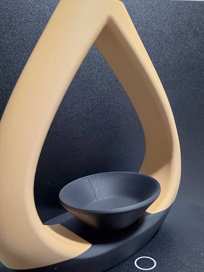 Close-up of a beige and black vase with a tea light holder