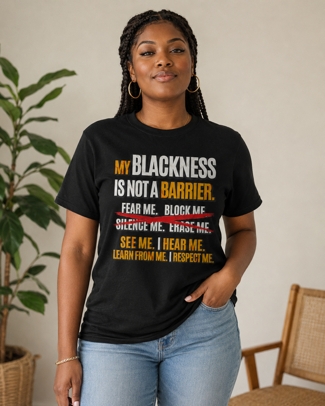 Person wearing a black t-shirt with a message about being Black, standing indoors.