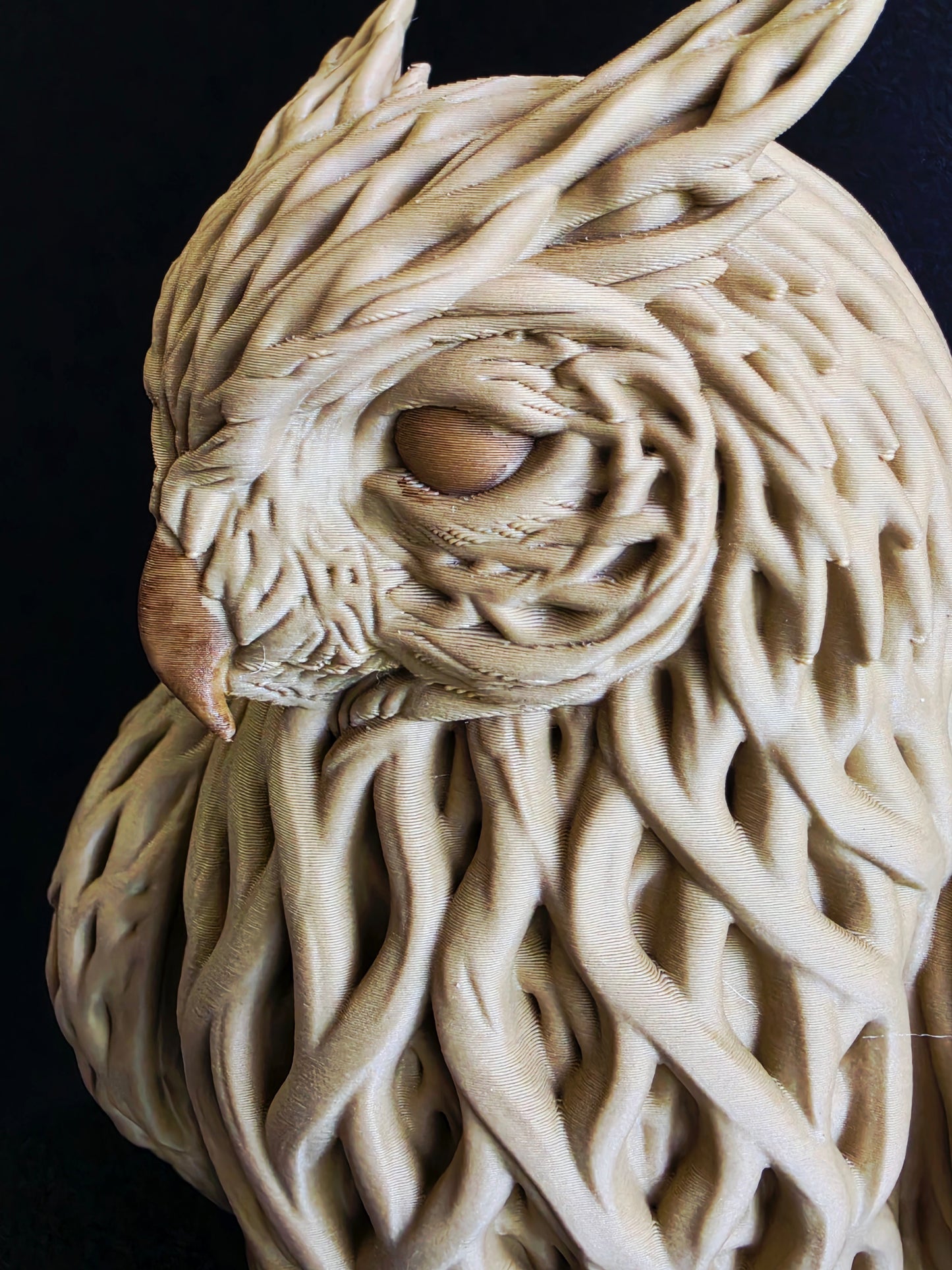 Close-up of a textured wooden sculpture owl on a black background