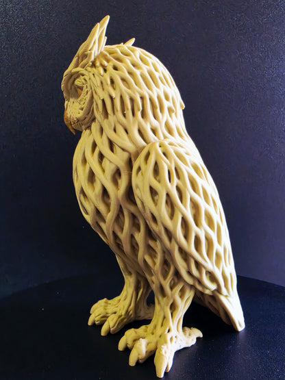 Yellow owl sculpture with intricate lattice design on a dark background