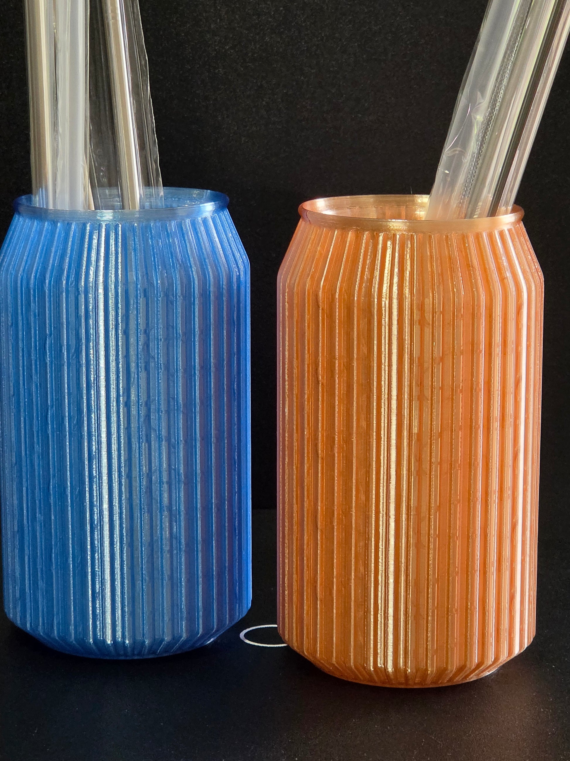Two cylindrical objects, one gold and one blue, on a black background