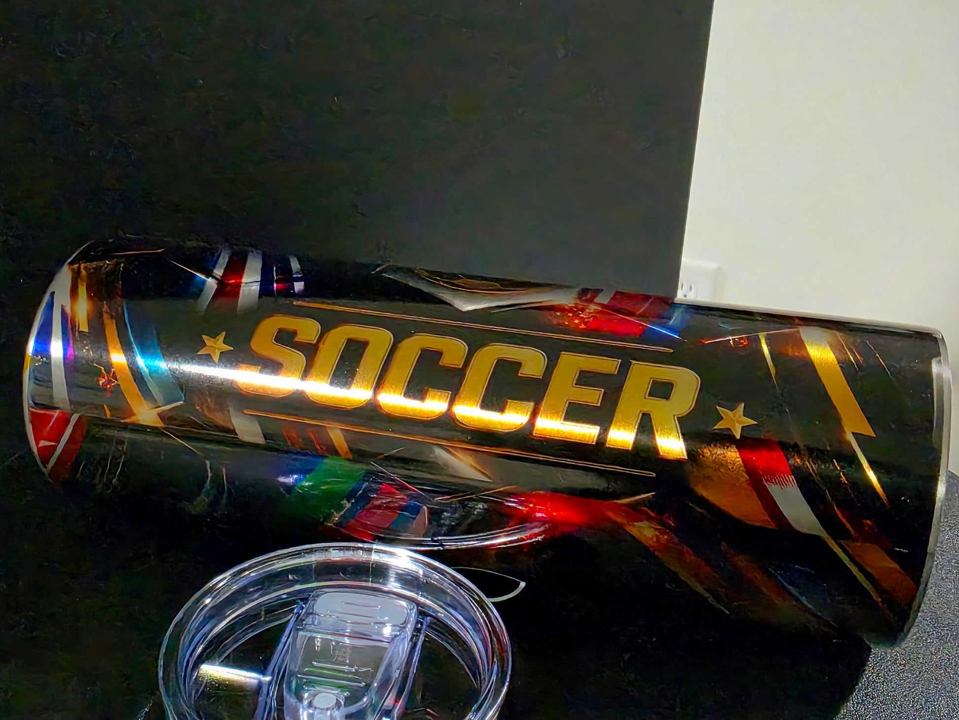 Metallic cup with 'SOCCER' text and international flags on a dark background