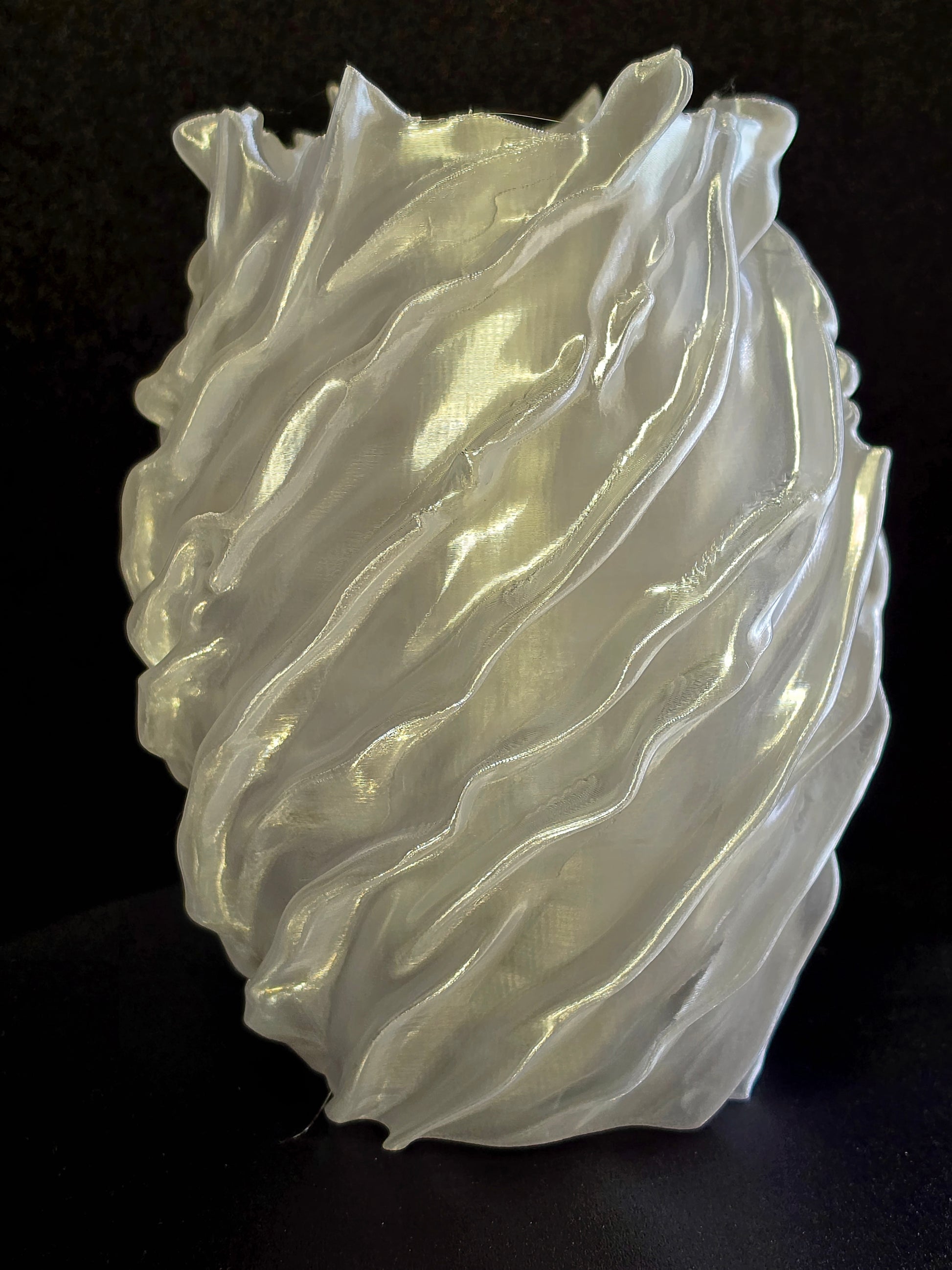 sculpture vase with wavy, layered design on a black background