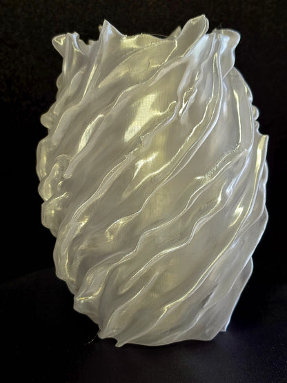 sculpture vase with wavy, layered design on a black background