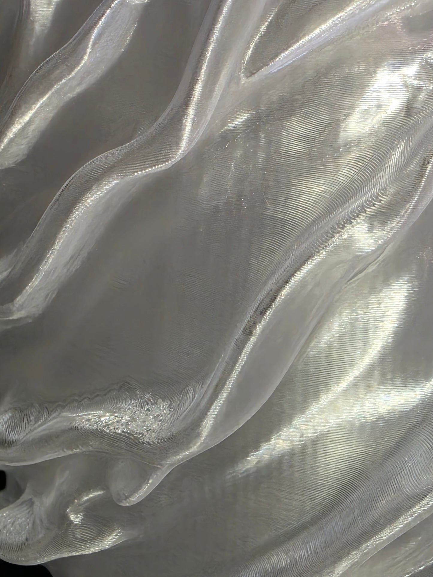 Close-up of a clear sculptural vase with reflective surface