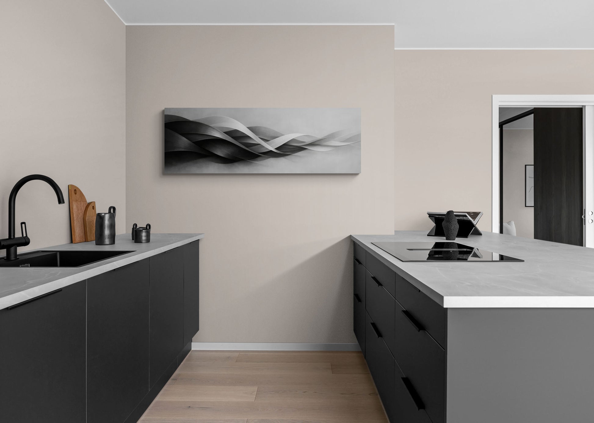 Modern kitchen with black cabinets, white countertops, and abstract wall art.