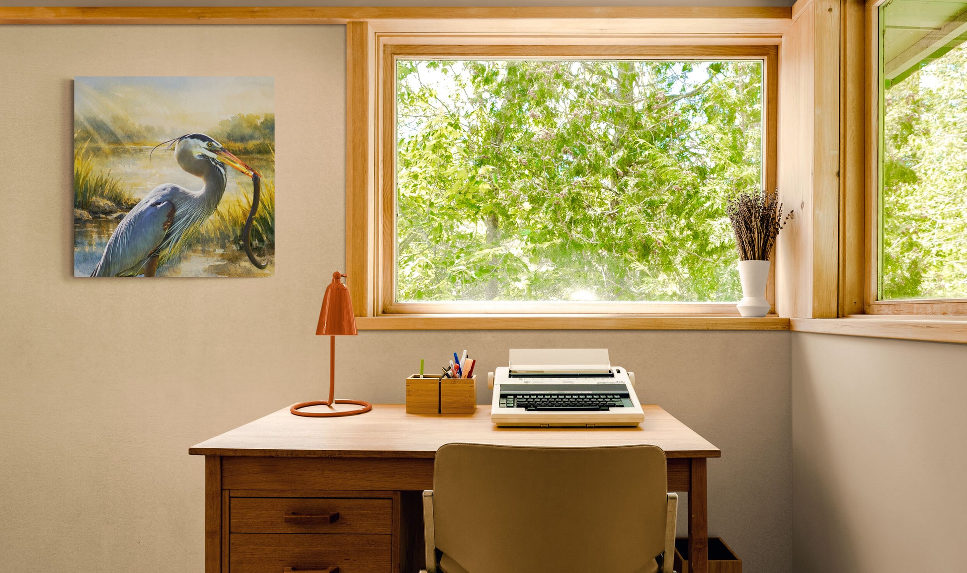 Home office with desk, chair, lamp, and artwork on a wall.