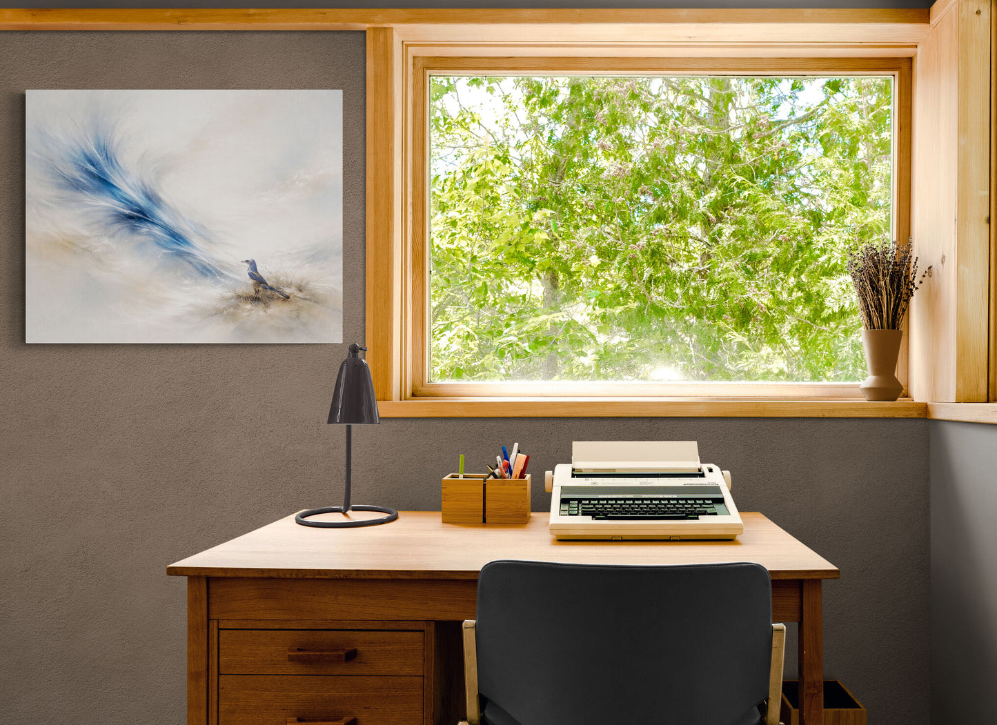 Home office with a desk, typewriter, lamp, and window view of greenery.
