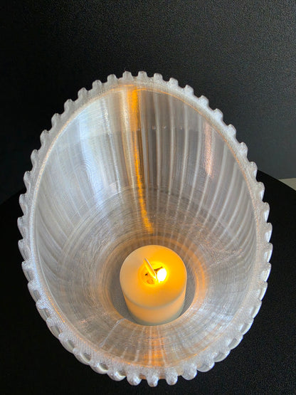 Decorative tealight holder with a candle on a black background