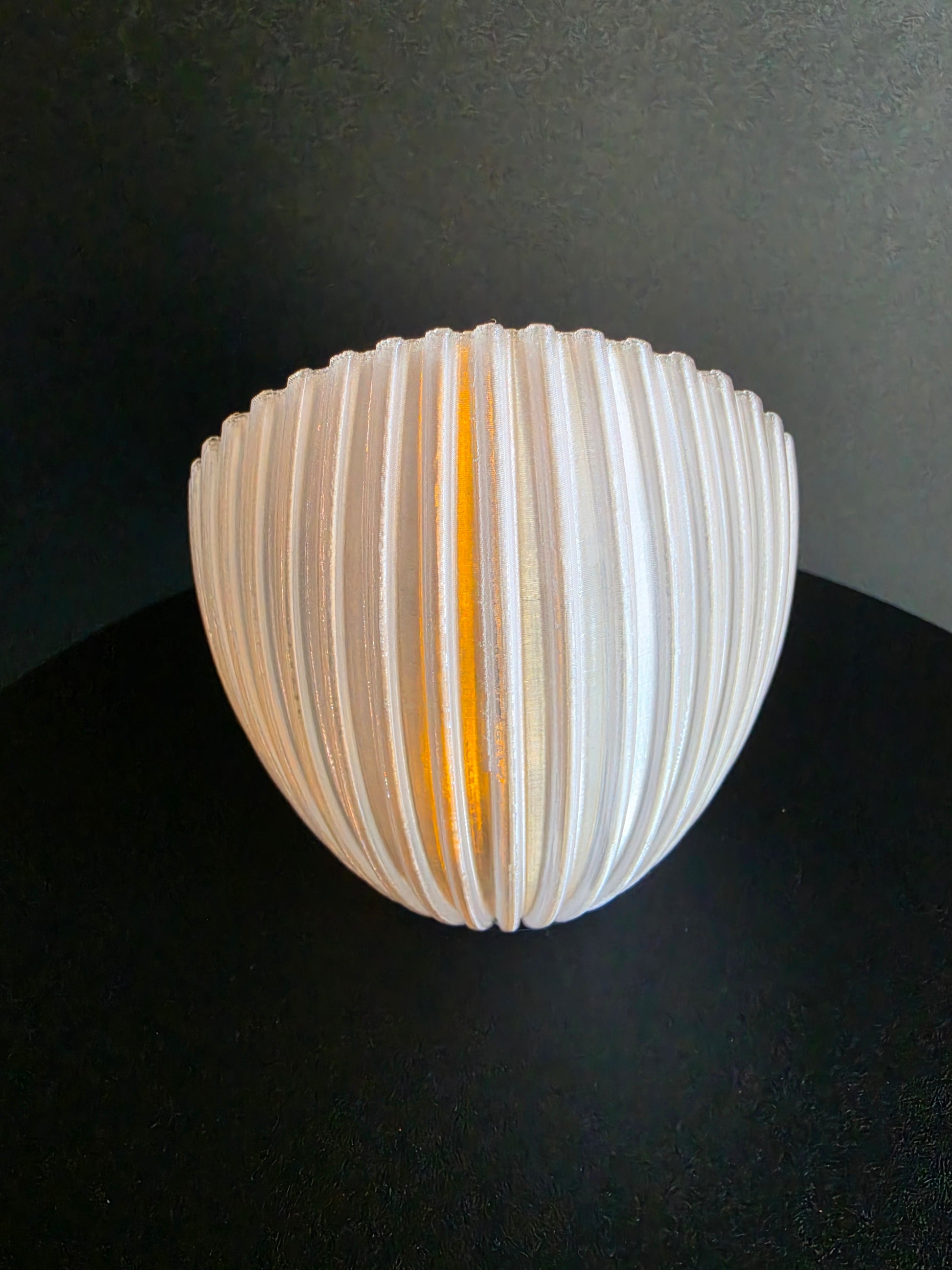 Spherical lamp with ribbed design on a dark background