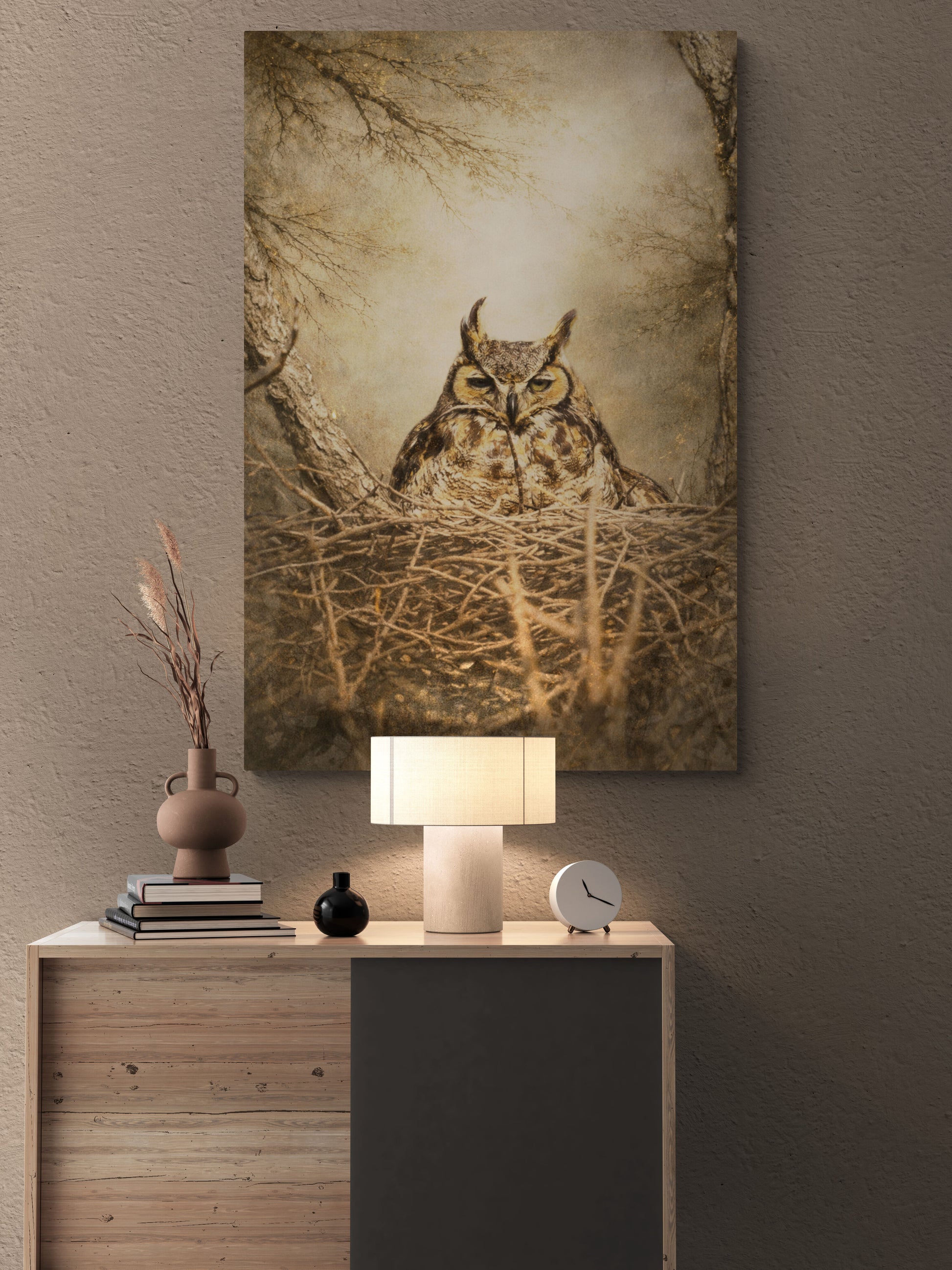 Canvas print of an owl in a nest on a wall above a wooden console table with decorative items.