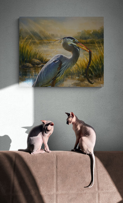 Two cats sitting on a couch below a painting of a heron by a lake.