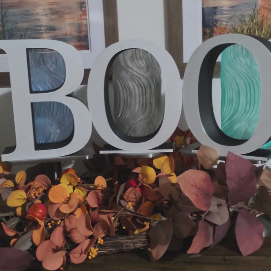 Large 9 inch letters that spell BOO placed on a console with fall decor.