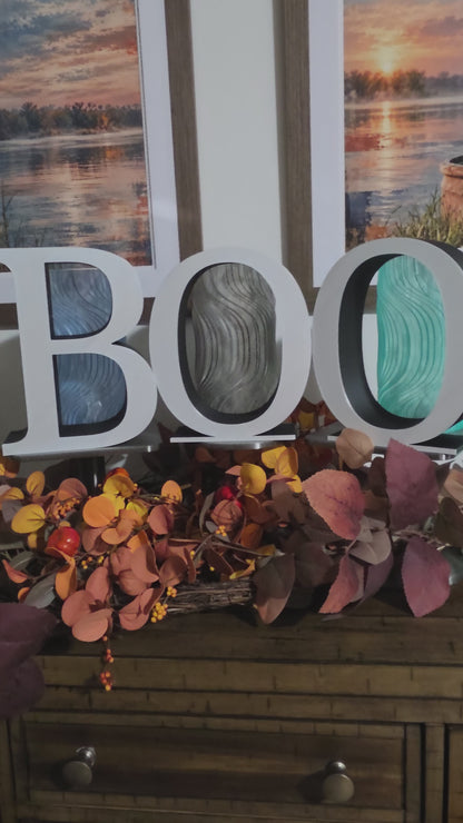 Large 9 inch letters that spell BOO placed on a console with fall decor.