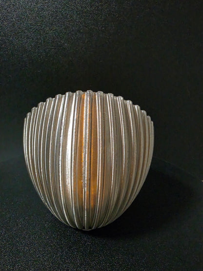 Round metallic light fixture on a dark background